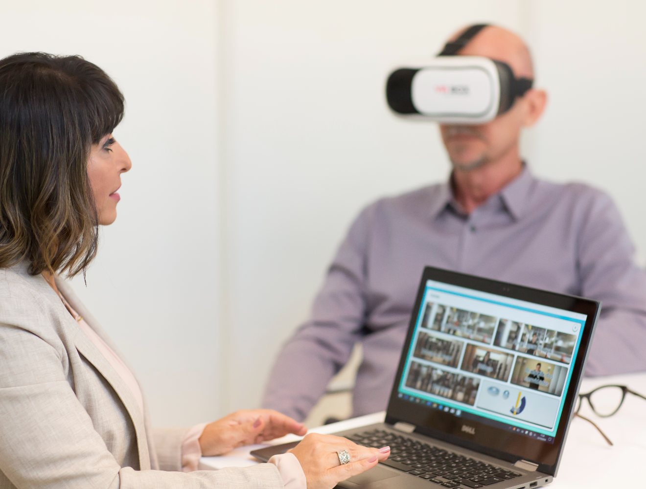 Psicóloga conduzindo a sessão pelo notebook enquanto o paciente usa os óculos de Realidade Virtual